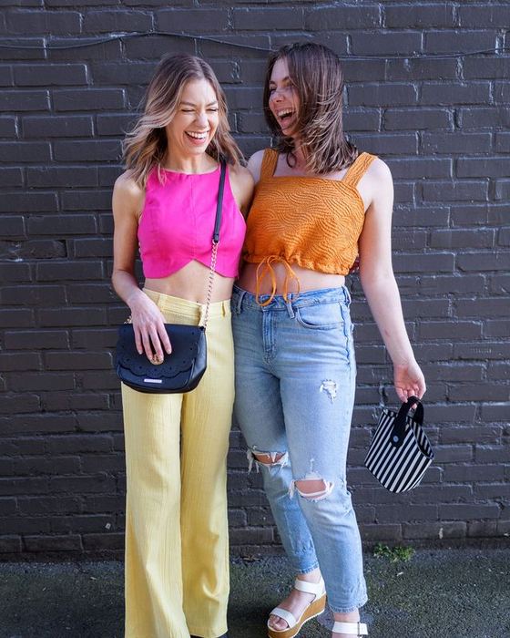 Yellow trousers and an orange top against the brick